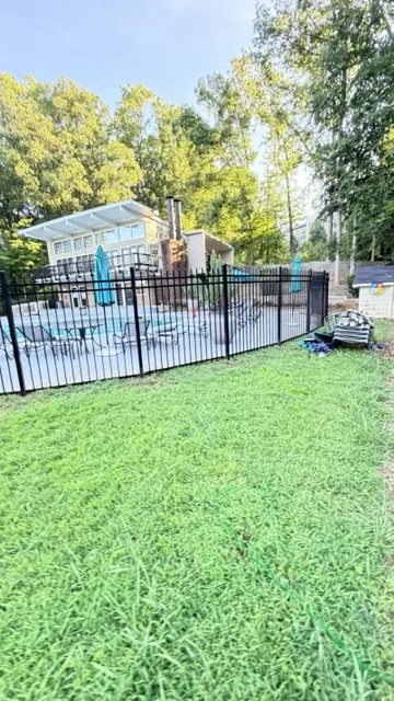 Black aluminum pool fence enclosing a community pool area, installed by Superior Fence & Rail of Raleigh