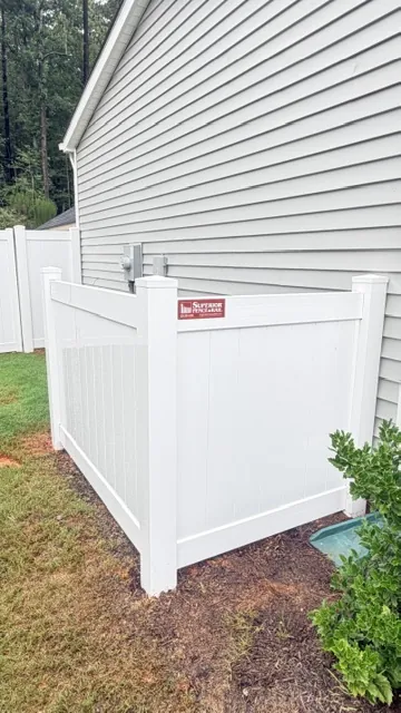White vinyl privacy fence screening utility equipment beside a home, installed by Superior Fence & Rail of Raleigh