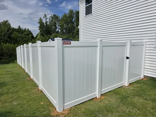 White vinyl privacy fence with a walk gate returning to the house, installed by Superior Fence & Rail of Raleigh