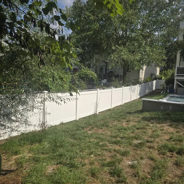 White vinyl privacy fence enclosing a back yard with a pool, installed by Superior Fence & Rail of Raleigh