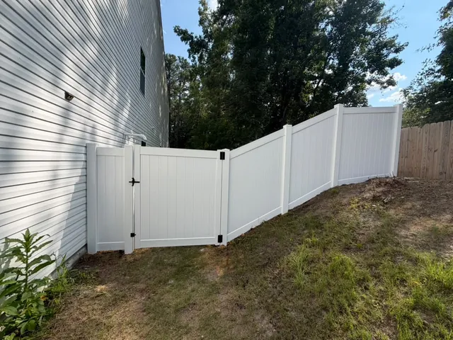 White vinyl privacy fence stepped down a sloping back yard, installed by Superior Fence & Rail of Raleigh
