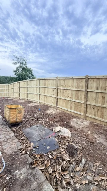 Pressure-treated wood privacy fence newly installed on a cleared back lot, installed by Superior Fence & Rail of Raleigh