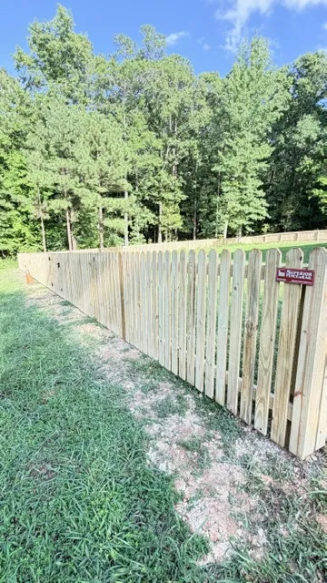 Pressure-treated wood privacy fence with a dog-ear picket top along a back yard, installed by Superior Fence & Rail of Raleigh